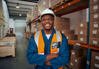 Portrait of a confident african factory engineer standing with his arm crossed in large warehouse