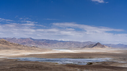 Panoramic view of high-altitude Tuzkul salt lake with mountain background along the Pamir Highway between Bulunkul and Alichur in Gorno-Badakshan, Tajikistan
