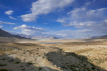Panoramic view of high-altitude Tuzkul salt lake with mountain background along the Pamir Highway between Bulunkul and Alichur in Gorno-Badakshan, Tajikistan