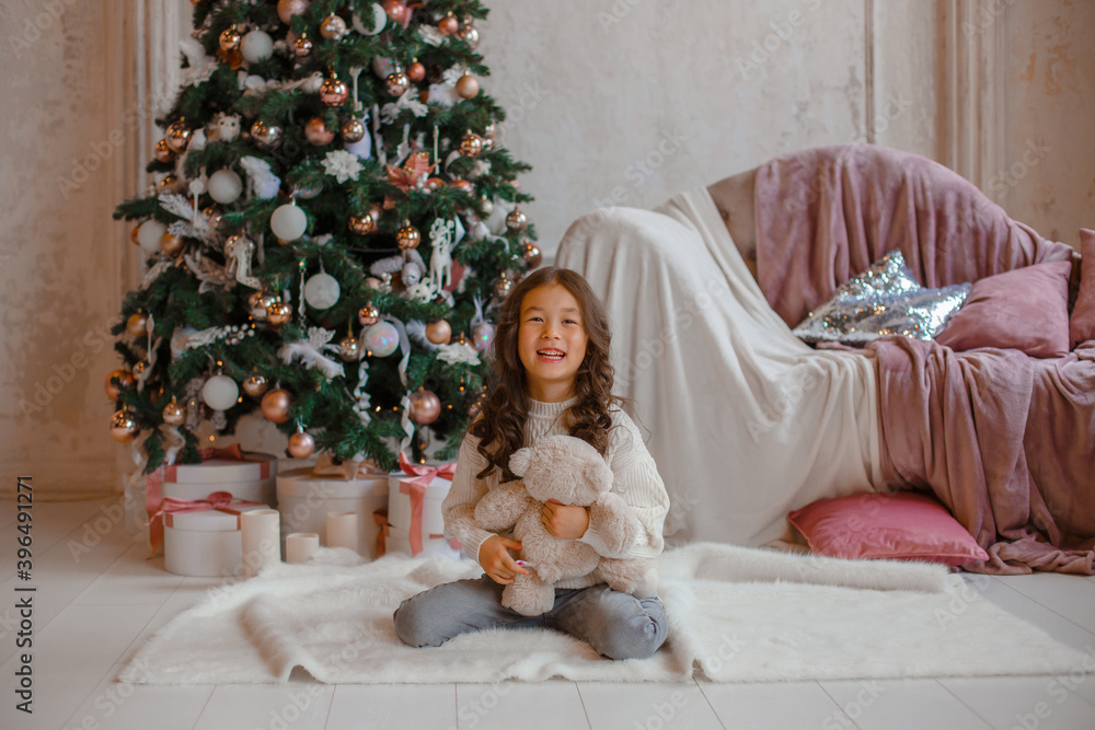 Wall mural girl with christmas tree hold bear Teddy