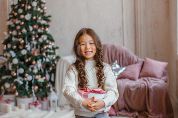 girl with christmas tree hold present