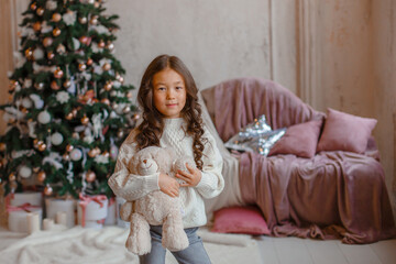 Obraz na płótnie Canvas girl with christmas tree hold bear Teddy