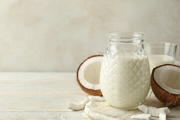 Board with fresh coconut and coconut milk on wooden background