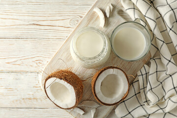 Board with fresh coconut and coconut milk on wooden background