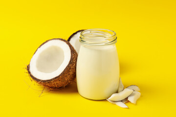 Fresh coconut and coconut milk on yellow background