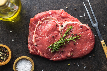 Sliced raw ribeye steak on black kitchen table.