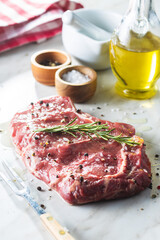 Sliced raw ribeye steak on white kitchen table.
