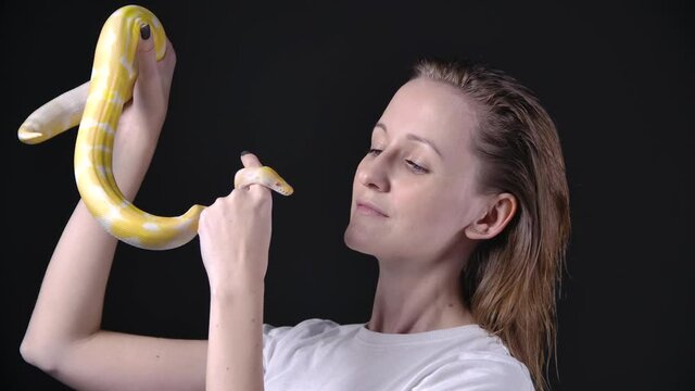 Slow motion shooting of woman putting up albino python