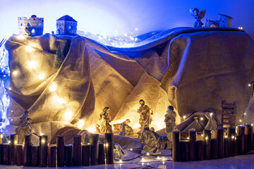 Decorated Christmas tree and creche on a blurred background, and you can see the lights and the...