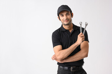 Mechanic in his uniform holding a spanner in his hand	