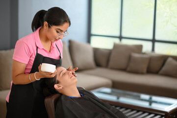 Woman getting her facial done at home 	