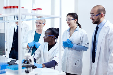 Team of scientists with diverse ethnicity analysing virus patology in modern facility. African...