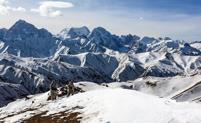 Two shooters with guns and camouflage in the winter mountains.