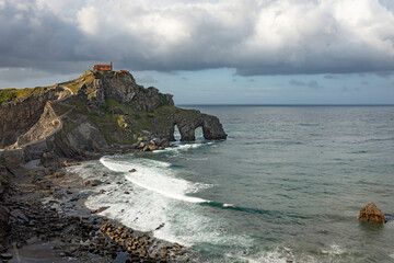 beautiful dramatic and cloudy landscape of a hermitage on a rock mountain within the sea