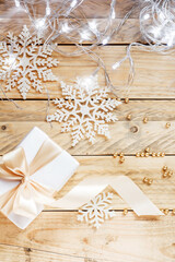 Christmas gift close-up on a wooden background. Christmas gift box on a background of wooden boards, with a christmas decor. Xmas present.