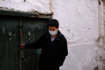 young man wearing a protective mask is leaving home.