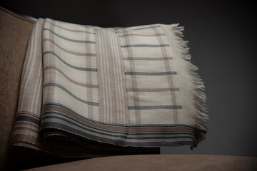 Close up of tassels of a shawl kept on a chair	