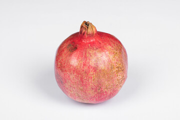 Large red pomegranate against white background