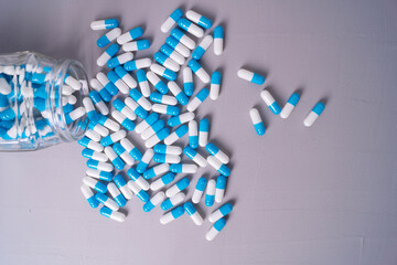 white and blue pills on a gray background. medical background