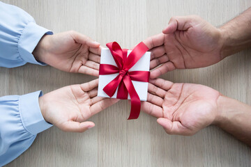 Women and men are giving gifts to each other.