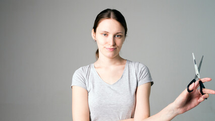 Naklejka premium Hairdresser holding scissors at gray studio background