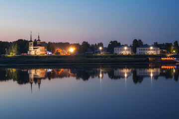 Fototapeta na wymiar embankment of an ancient city reflected in the river in the evening