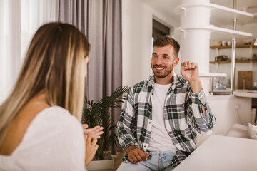 Fototapeta premium Young couple talking using sign language at home.