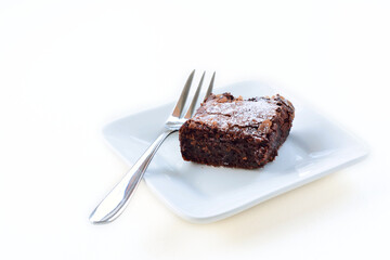 Piece of chocolate brownies served on a square plate.