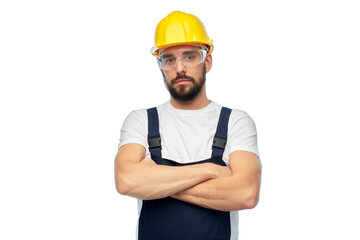 profession, construction and building - male worker or builder in yellow helmet and goggles with crossed arms over white background