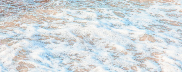 the waves of the sea on the sandy beach on a sunny day