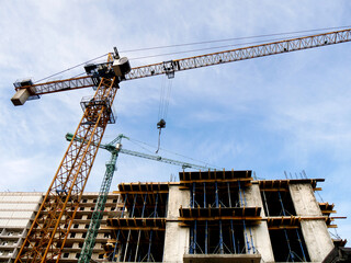 Construction site background. Hoisting cranes and new multi-storey buildings. Industrial background.