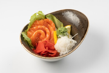 Sushi sashimi. Salmon slices with red caviar, radish daikon ibir, wasabi, lettuce and lemon wedge on a rice pad.