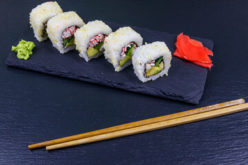 Uramaki sushi rolls with surimi on a black slate