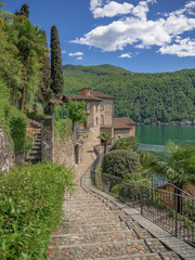 Fototapeta na wymiar narrow path leads to viewpoint on the hill of Morcote, an amazing medieval village overlooking the Lugano lake.Ticino, Svizzera