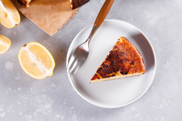Piece of San Sebastian Basque Cheesecake on the plate on a light background. Top view