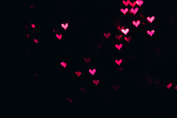 Fototapeta na wymiar Defocused bokeh lights in shape of pink and red hearts.
