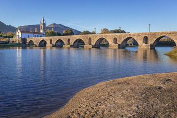 Fototapeta premium Famous Roman bridge in Ponte de Lima town, Portugal - view with Santo Antonio da Torre Velha church