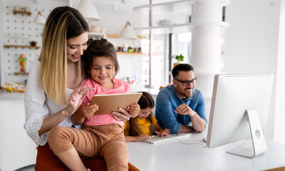 Business parents interrupts by her children while working in home office