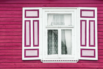 Pink window background. Old window frame. Cottage house architecture. Open window shutters.	