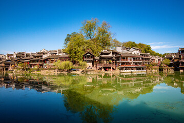 Fototapeta na wymiar the river, the boat, stone bridge and the old houses at ancient phoenix town in the morning at Hunan, China.
