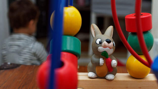 Children's toys around the house. A smiling plastic rabbit with a carrot in his arms.