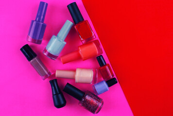 Nail polishes on bright pink and red background