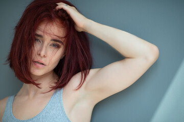 Fototapeta premium Beautiful young stylish ginger woman wearing casual clothes posing at home.