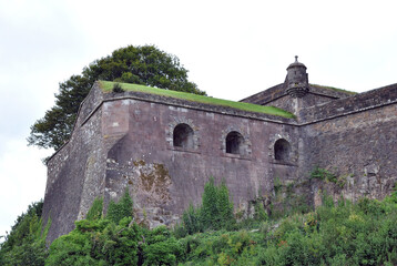Fototapeta na wymiar Old Stone Walls of Castle with Gun Ports seen from Below