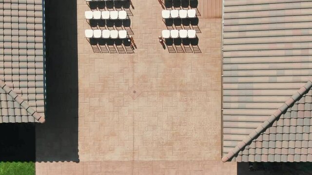WS AERIAL Drone POV HA Rows of chairs and roof of large building