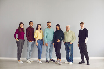Group of diverse people in casual clothes standing together and looking at camera