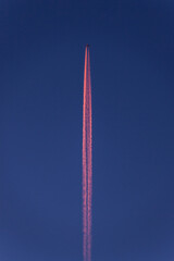 Airplane making colorful contrails in the sky