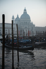 Picturesque view of ancient buildings, bridge and channel with gondolas in Venice, Italy, twilight.