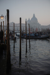 Picturesque view of ancient buildings, bridge and channel with gondolas in Venice, Italy, twilight.