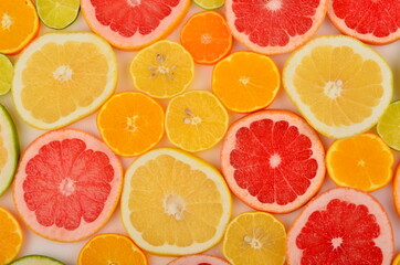 Sliced citrus fruits background. Red grapefruit, oranges, lemons, lime, mandarins